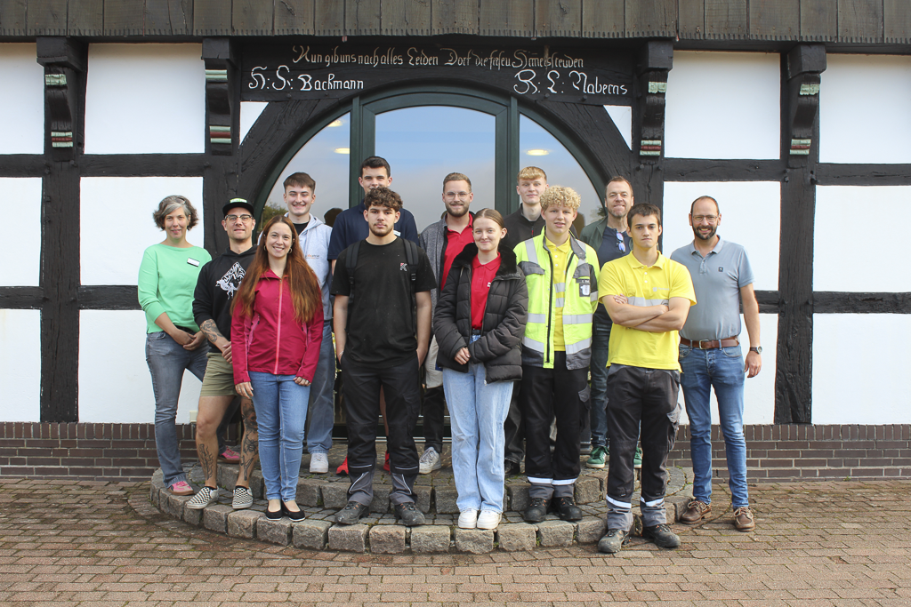 Gruppenbild vor einem Fachwerkhaus: Auszubildende und leitende Mitarbeitende nehmen gemeinsam am Social Day teil.